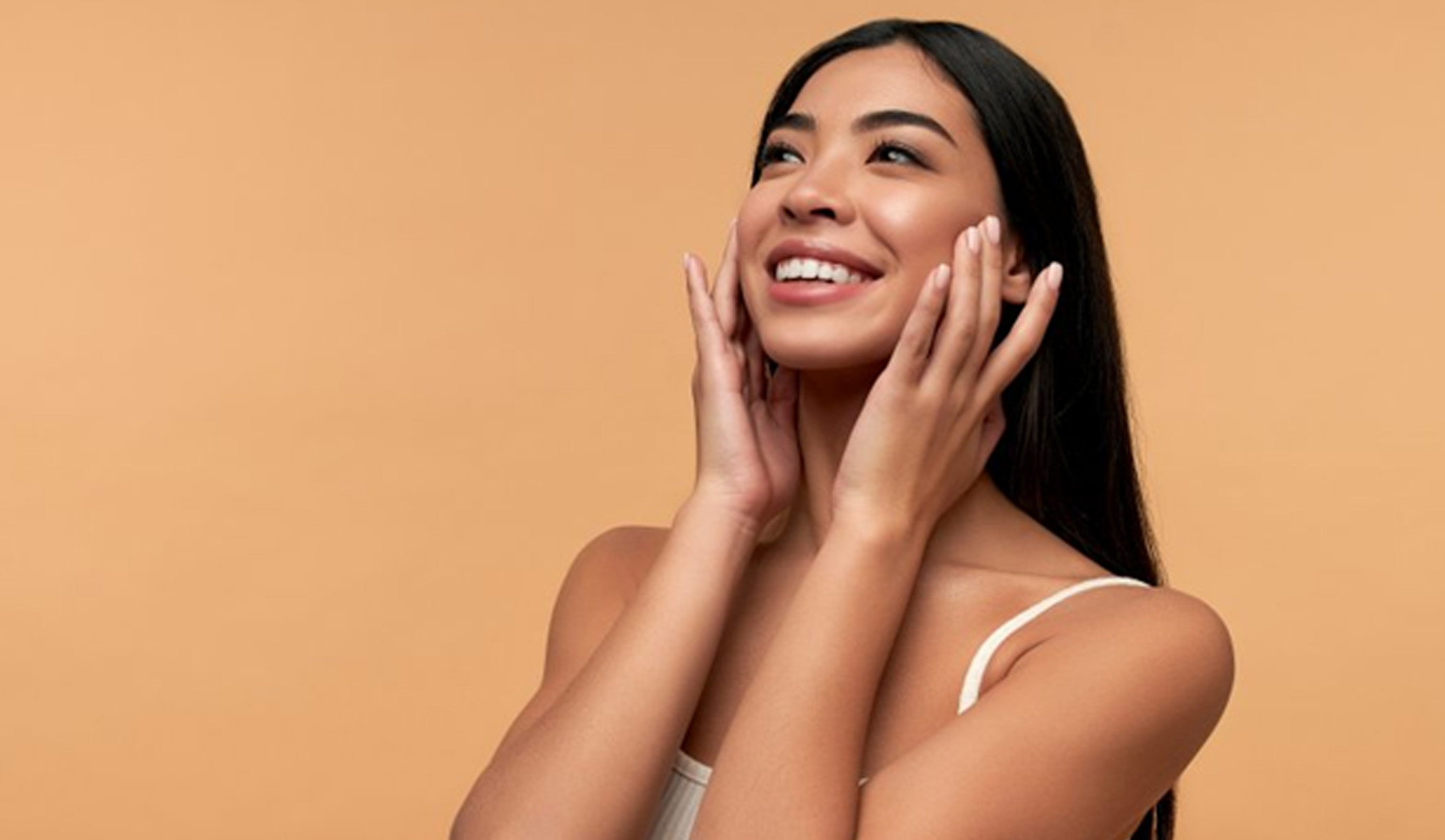 a woman smiling while touching her face