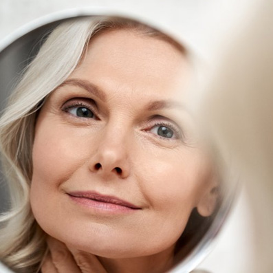a woman looking in the mirror and smiling