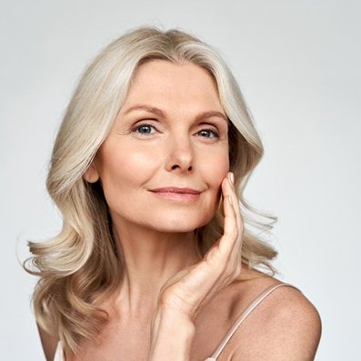 a woman touching her cheek after receiving BOTOX