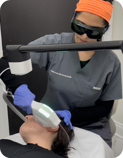 Doctor Azam holding a medical device shining concentrated light onto a patients face