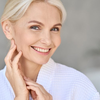 a woman smiling and touching her soft skin