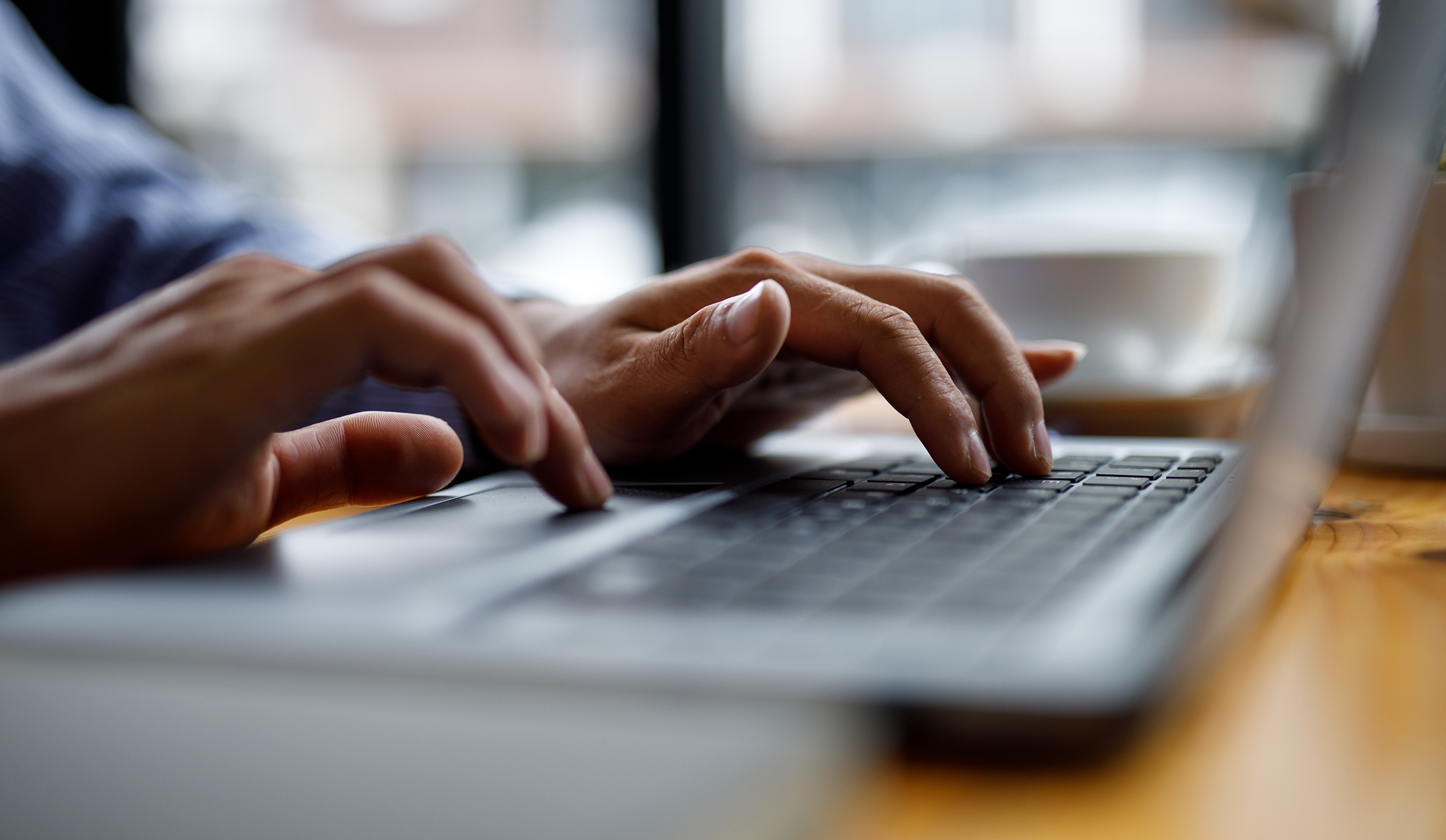 Close up of hands typing on a laptop