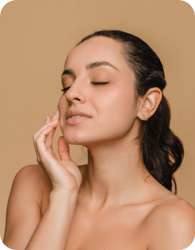 A woman with her hands on her face, reflecting on dental rejuvenation and its impact on her confidence.